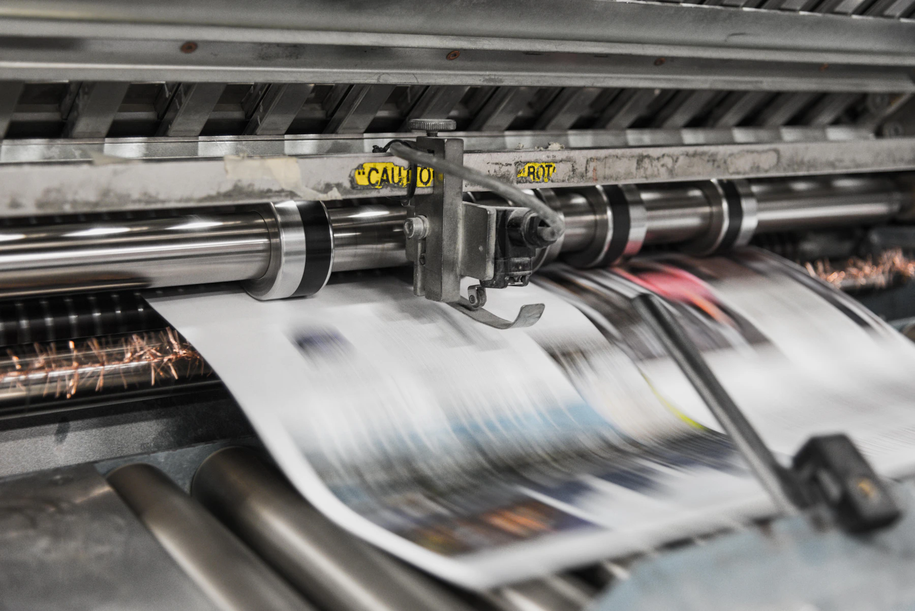 Paper moving through a commercial printing press
